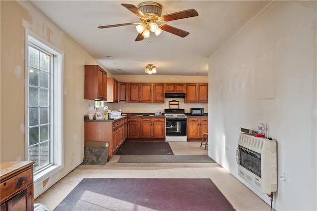 kitchen featuring ceiling fan, white stove, and heating unit