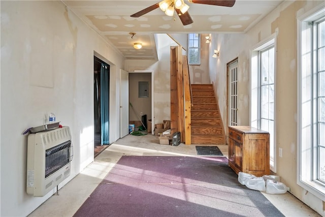 interior space with heating unit, ceiling fan, and electric panel