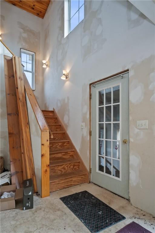 stairs with a wealth of natural light and a high ceiling