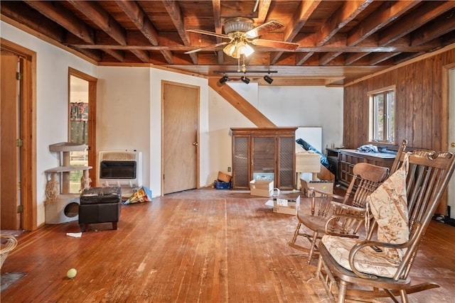 sitting room with wood walls, ceiling fan, wood-type flooring, wood ceiling, and heating unit