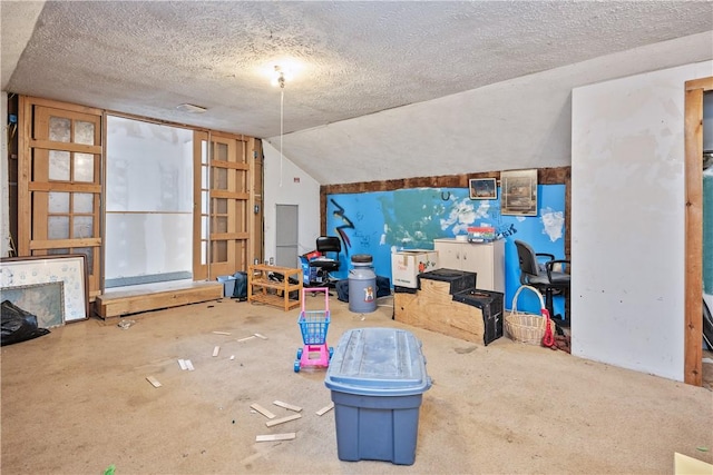 interior space with a textured ceiling and vaulted ceiling