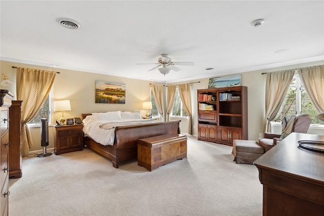 bedroom with ceiling fan, light colored carpet, and crown molding