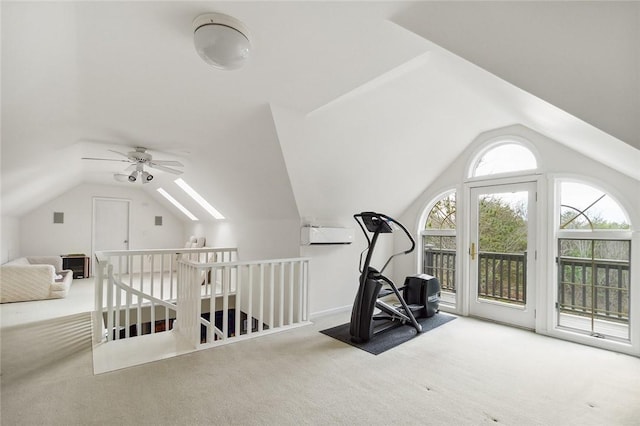 exercise room featuring ceiling fan, carpet, and lofted ceiling with skylight