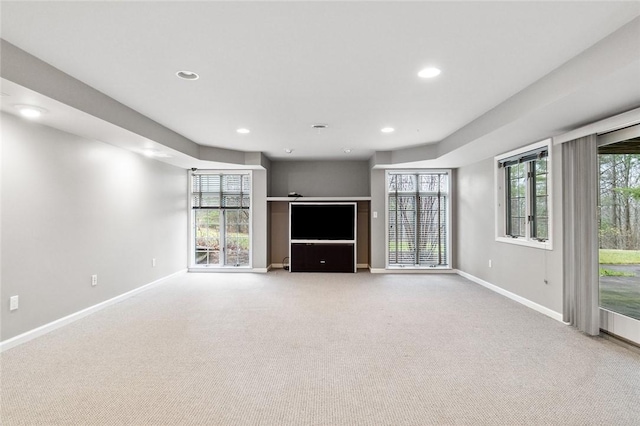 unfurnished living room with a wealth of natural light and light carpet