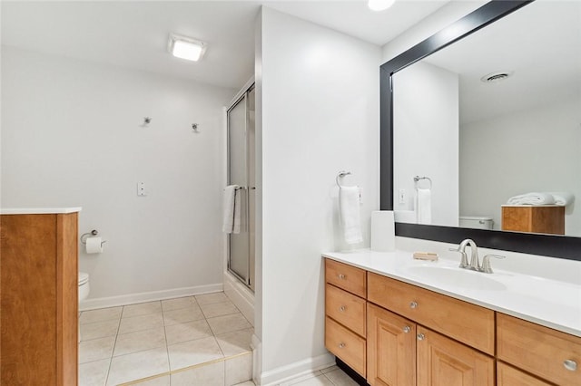 bathroom with tile patterned flooring, vanity, toilet, and a shower with door