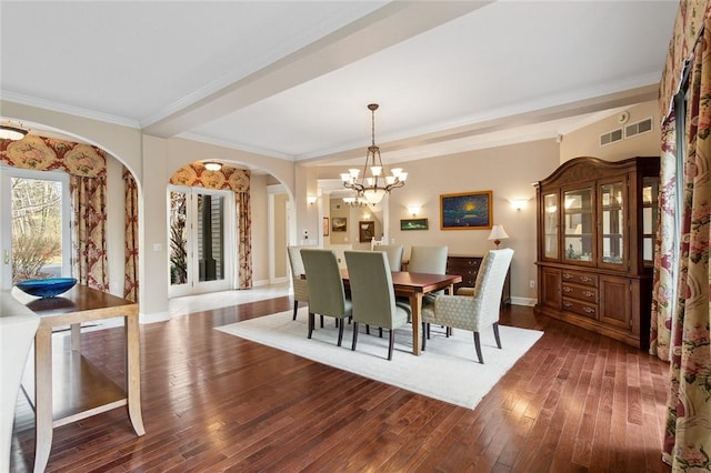 dining room with crown molding, dark wood-type flooring, and a notable chandelier