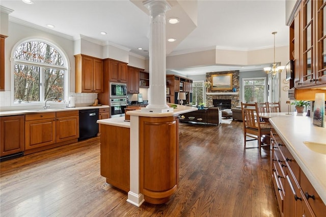 kitchen with tasteful backsplash, stainless steel appliances, sink, a fireplace, and a center island