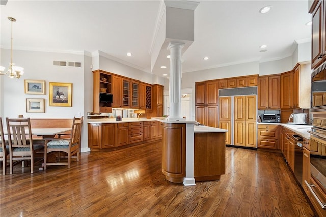 kitchen with a center island, paneled refrigerator, decorative columns, a chandelier, and pendant lighting