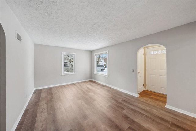 unfurnished room featuring a textured ceiling and hardwood / wood-style flooring