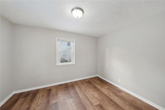 unfurnished room with hardwood / wood-style floors and a textured ceiling