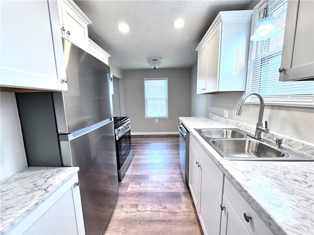 kitchen featuring white cabinetry, sink, dark wood-type flooring, a textured ceiling, and appliances with stainless steel finishes