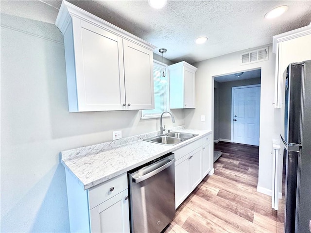 kitchen with dishwasher, white cabinets, fridge, and sink