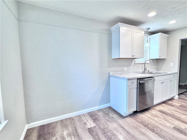 kitchen with white cabinets, sink, stainless steel dishwasher, a textured ceiling, and light hardwood / wood-style floors