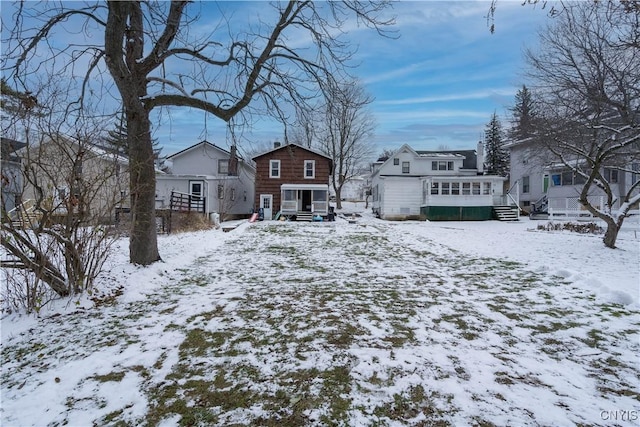 view of snow covered rear of property