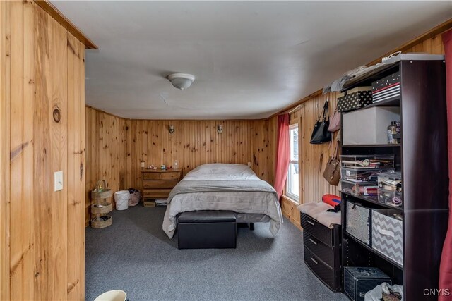 bedroom with carpet flooring and wood walls