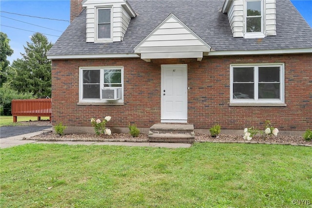 cape cod home featuring a front lawn