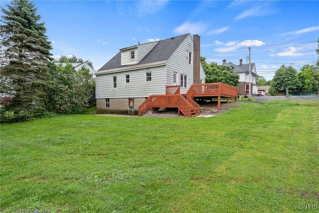 rear view of property featuring a wooden deck and a yard