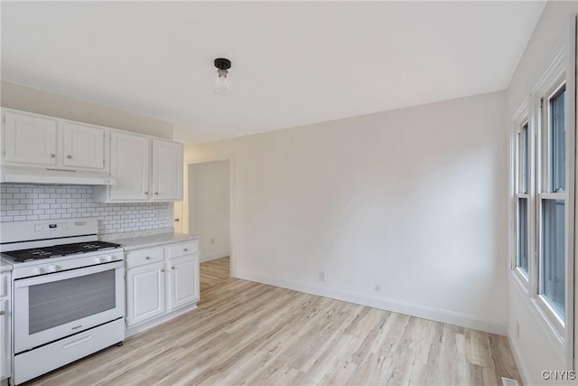 kitchen with white range oven, white cabinetry, and tasteful backsplash