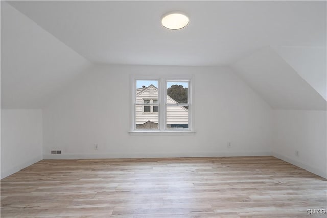 additional living space with lofted ceiling and light wood-type flooring