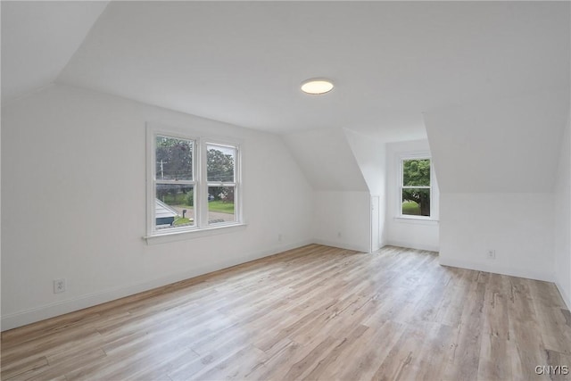 bonus room with vaulted ceiling, light hardwood / wood-style flooring, and a healthy amount of sunlight