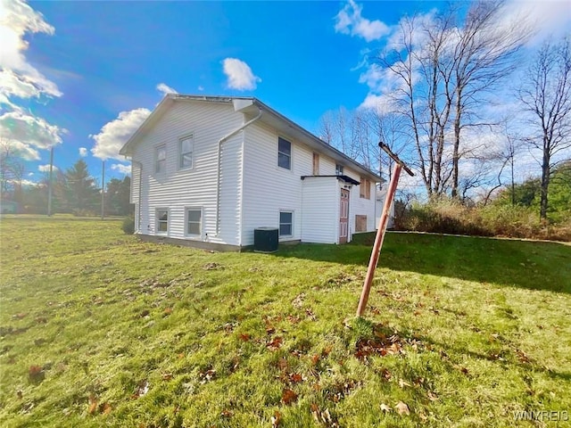 view of side of property with a lawn and central AC unit