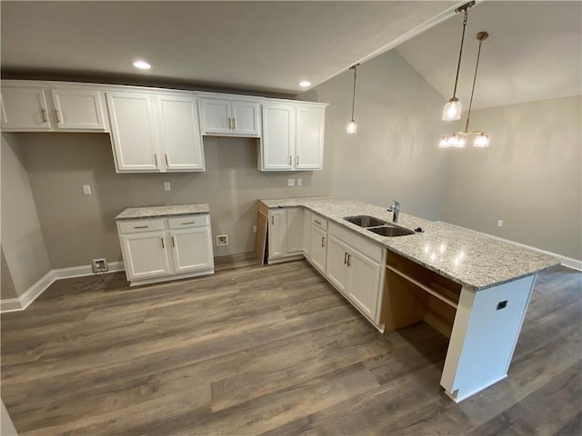 kitchen with light stone countertops, sink, hanging light fixtures, dark hardwood / wood-style floors, and white cabinets