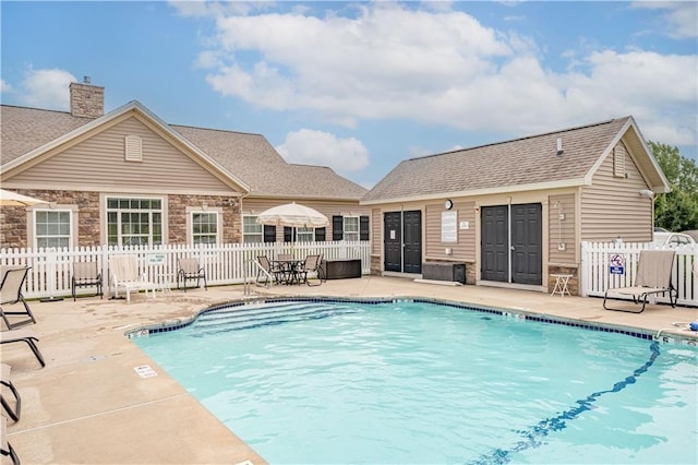 view of swimming pool featuring a patio area and an outbuilding