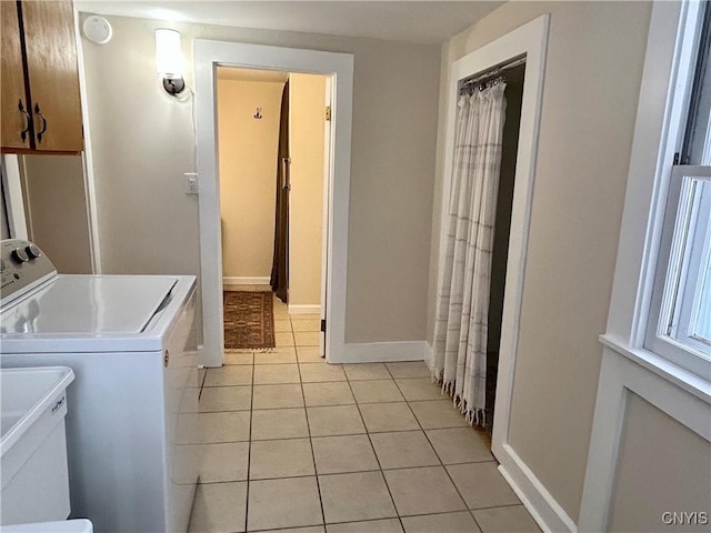 laundry area featuring washer and dryer and light tile patterned flooring