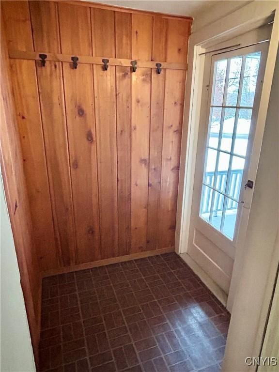 entryway with wood walls