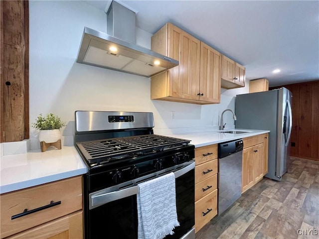 kitchen with light brown cabinets, wall chimney range hood, sink, hardwood / wood-style flooring, and appliances with stainless steel finishes