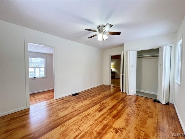 unfurnished bedroom featuring ceiling fan, light wood-type flooring, and a closet