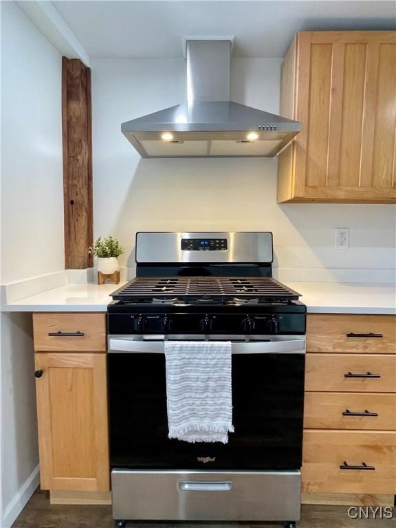 kitchen featuring gas range, light brown cabinetry, dark hardwood / wood-style flooring, and wall chimney exhaust hood