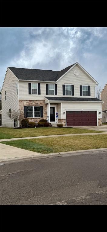 view of front facade featuring a front yard and a garage