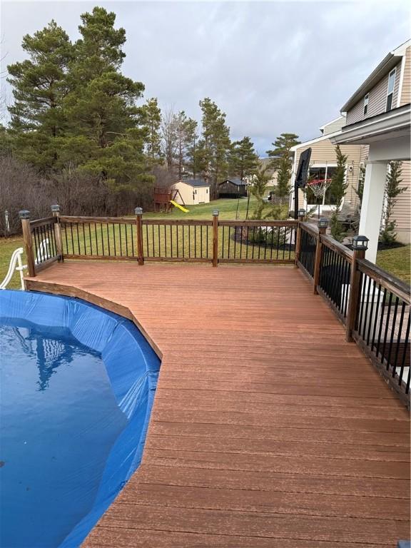 view of swimming pool with a yard and a deck