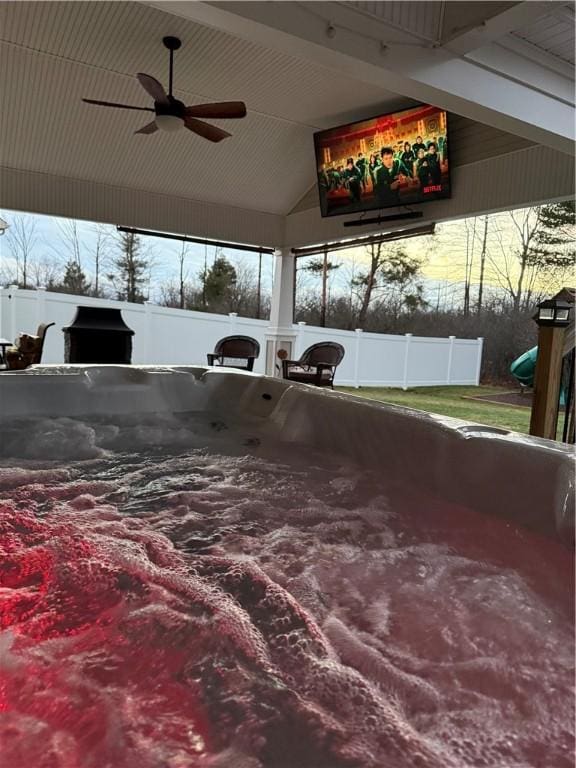 view of patio / terrace with area for grilling, ceiling fan, and a hot tub