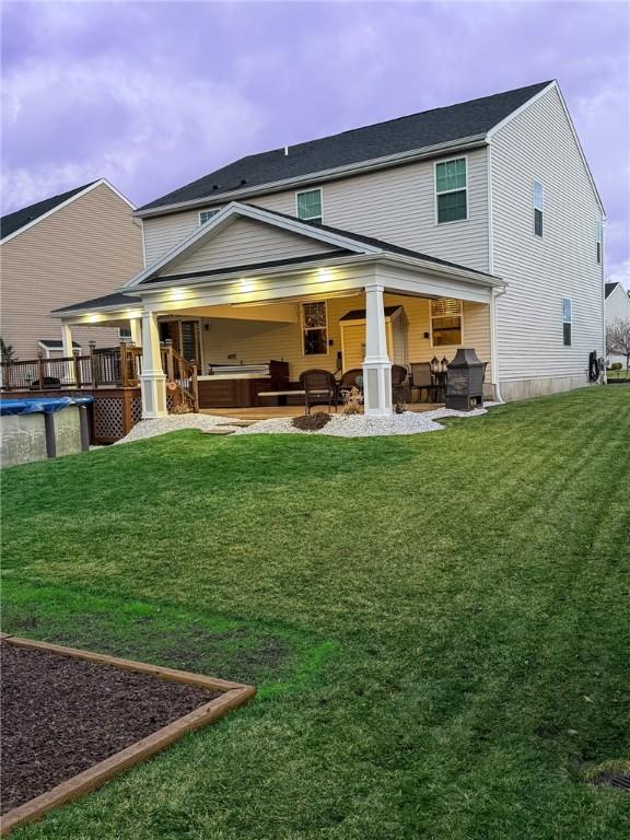 back of property featuring a lawn, an outdoor hangout area, and a patio