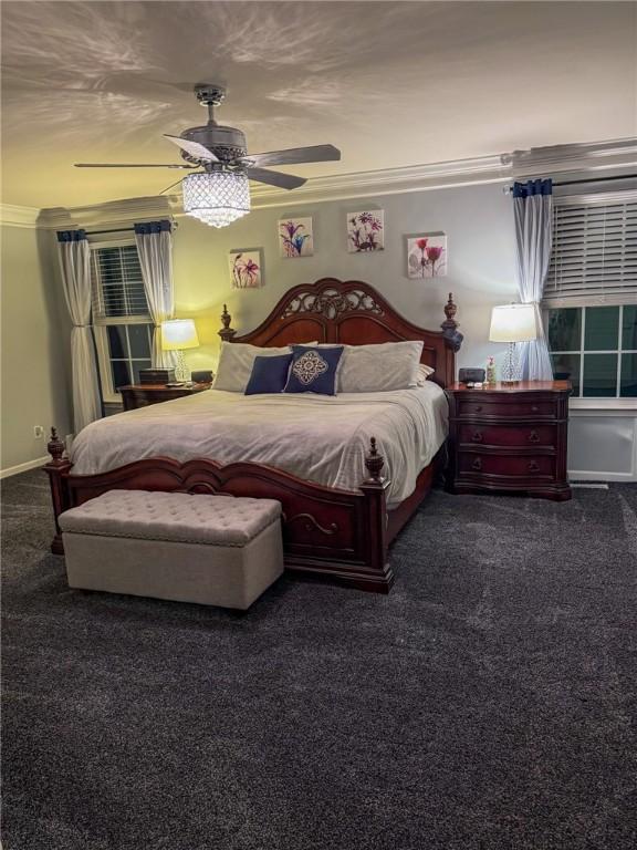 carpeted bedroom featuring ceiling fan and crown molding