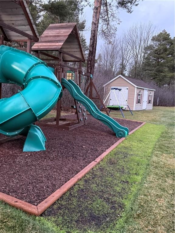 view of play area featuring a yard and a shed