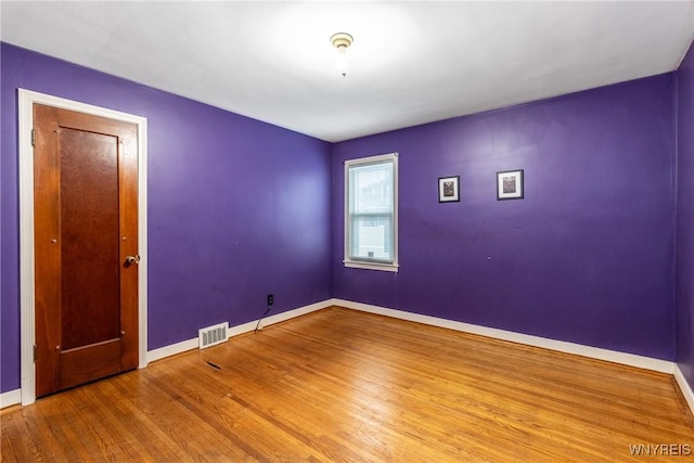 spare room featuring wood-type flooring