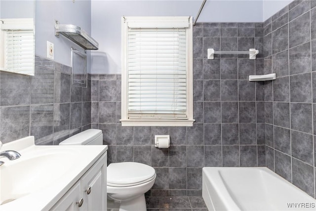 full bathroom with vanity, bathtub / shower combination, tile walls, and toilet