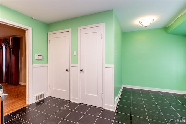 hallway featuring dark tile patterned floors