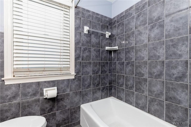 bathroom featuring toilet and tile walls