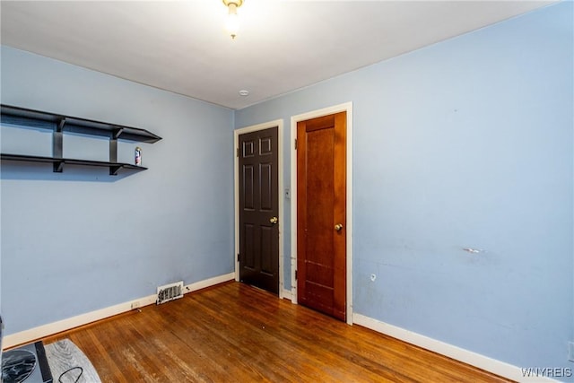 empty room with dark hardwood / wood-style flooring