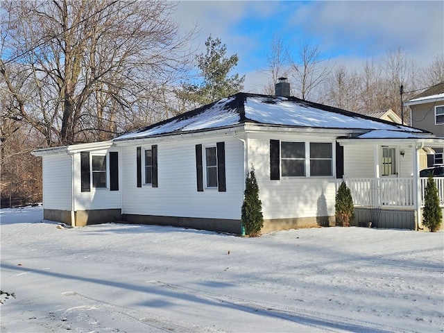 view of snowy exterior featuring covered porch