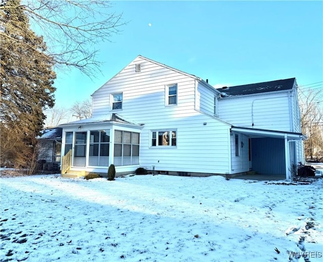 snow covered house with a sunroom