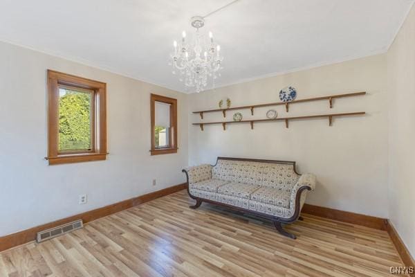 sitting room featuring a notable chandelier and light hardwood / wood-style flooring