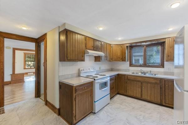 kitchen with stainless steel refrigerator, white range with electric cooktop, and sink