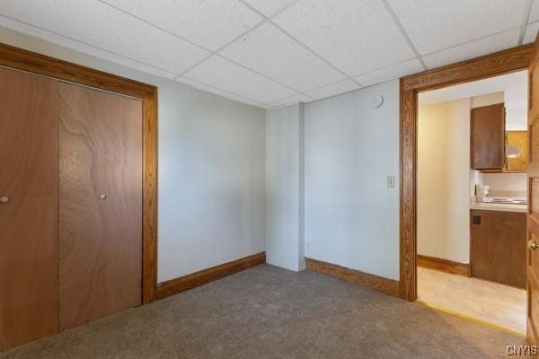 empty room featuring carpet and a drop ceiling