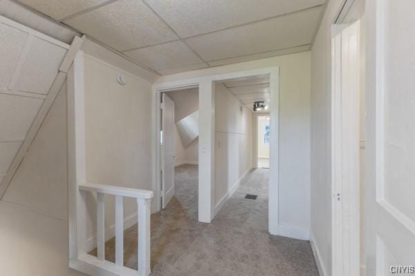 corridor featuring a drop ceiling and light colored carpet