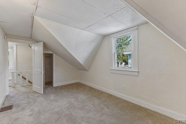 bonus room featuring light carpet and lofted ceiling